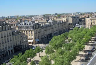 Luftaufnahme der Allées de Tourny in Bordeaux mit Hausmann-Gebäuden, grünen Bäumen und Steinfassaden.