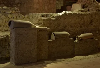 Archäologische Überreste der Ausgrabungsstätte Saint-Seurin in Bordeaux: antike Keramik- und Tongefäßfragmente auf Steinblöcken in einer unterirdischen Grabung.