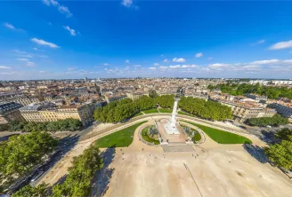 Luftaufnahme der Esplanade des Quinconces in Bordeaux mit dem Girondisten-Denkmal in der Mitte, umgeben von Gärten und Bäumen, dominiert von haussmannischer Architektur