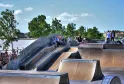 Skatepark in Bordeaux mit Betonrampen, Skatern und Zuschauern, Blick auf die Garonne und Bordeaux-Architektur